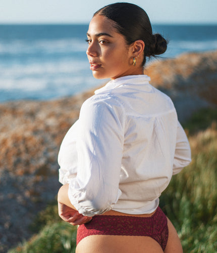 Bordeaux Hangover Lace Thong met tweede-huidpasvorm, gestyled met een wit overhemd in een kustlandschap.